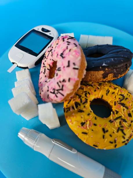 Sweet donuts, a glucometer, sugar cubes and an insulin pen