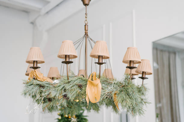Vintage chandelier with candelabra, decorated with pine branches, cones and ribbons