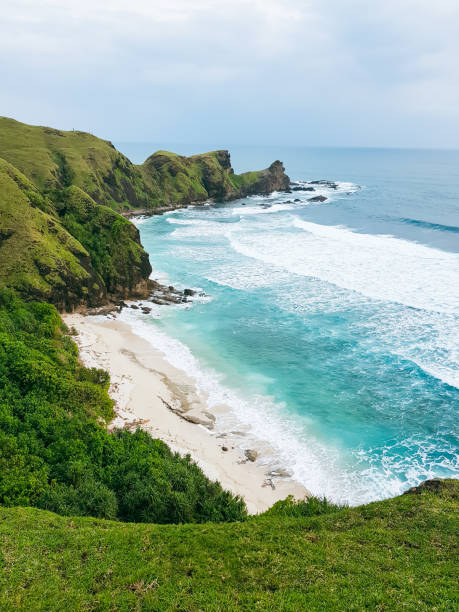 istock A dramatic coastline with steep green hills meeting the clear, blue ocean, while the sky displays a peaceful cloudscape 2178817292