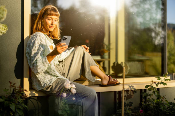istock Relaxing with Phone in Sunlit Garden 2178821556