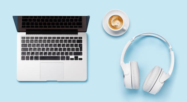 istock Laptop, headphones, and coffee cup arranged on a blue background 2178823617