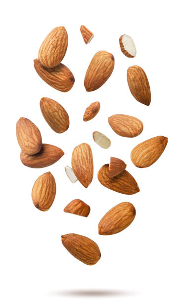 istock Almond kernels and pieces flying on white background. Isolated 2178826638