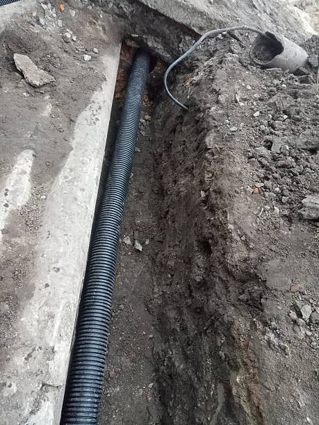istock a long black plastic pipe that lies in a trench 2178827038