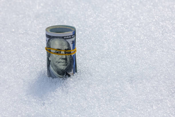 istock Roll of us dollar banknotes on the snow surface 2178827901