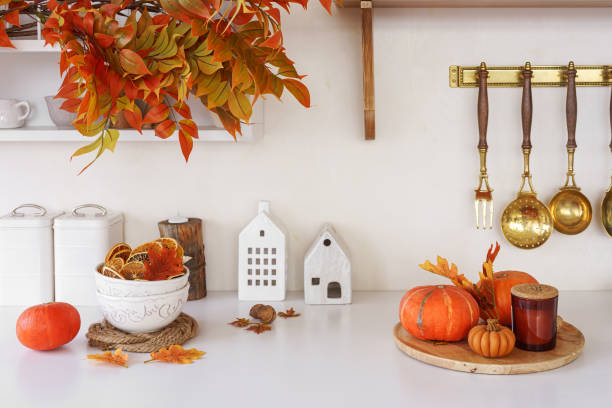 istock Fall decor with orange pumpkins, autumn leaves in cozy setting on white kitchen background 2178828871