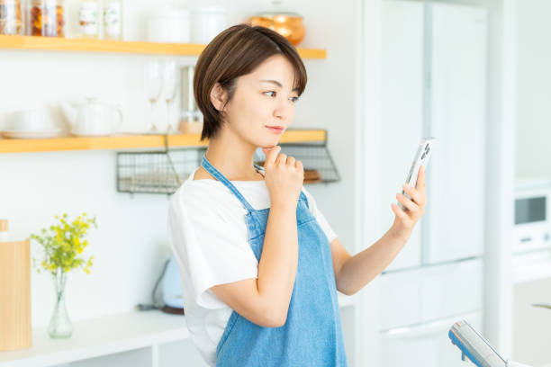 istock Woman with smartphone in the kitchen 2178831164