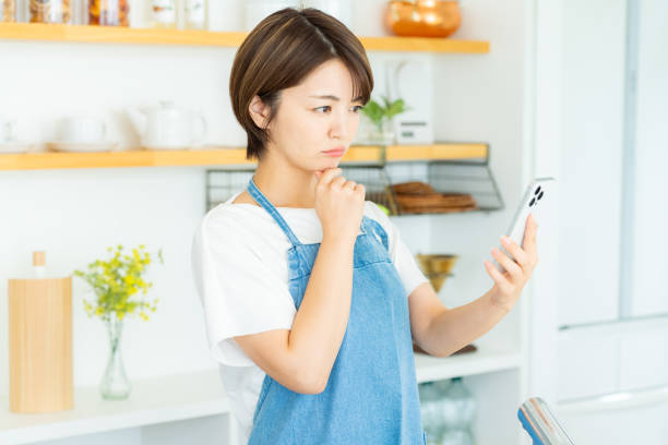 istock Woman with smartphone in the kitchen 2178831171