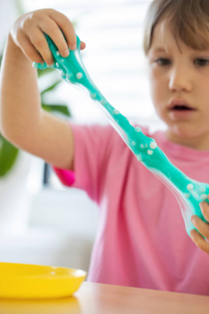 istock A child playing with bright, blue slime, enjoying a fun and creative indoor activity. 2178831465