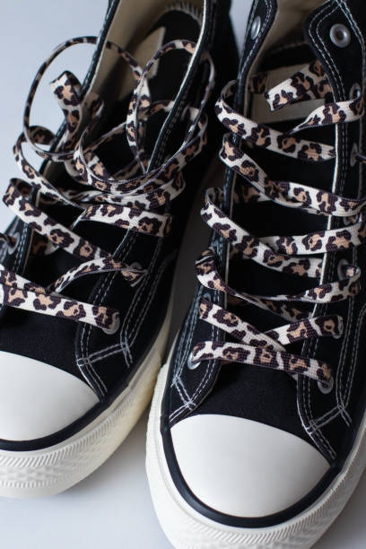 Black fabric and rubber sneakers with leopard printed laces.