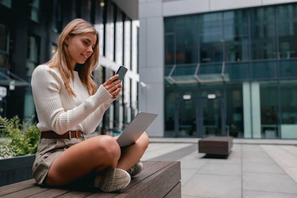 istock A Young Woman Engaged in Working on Her Laptop Outdoors Within a Modern Urban Setting 2178834950