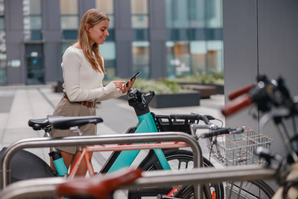 istock A woman is using her smartphone while she stands at a bicycle rack in an urban setting 2178839549