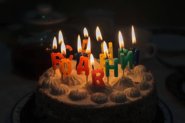 istock Festive birthday cake with lit candles on a blurred dark background. 2178841336