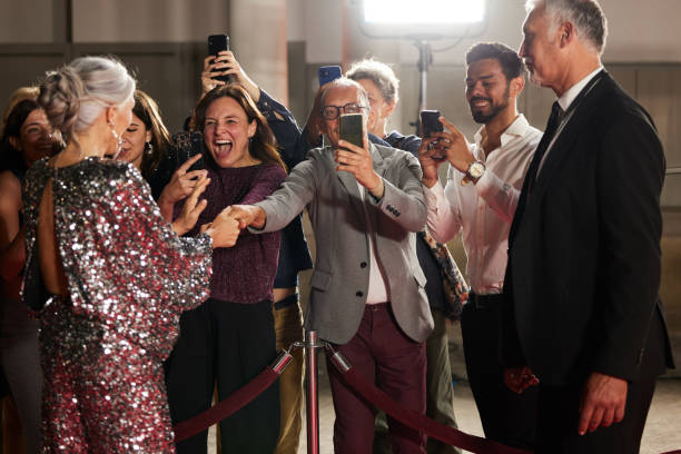 istock Fans cheer loudly at the red carpet event as they eagerly ask the actors for autographs. 2178843111