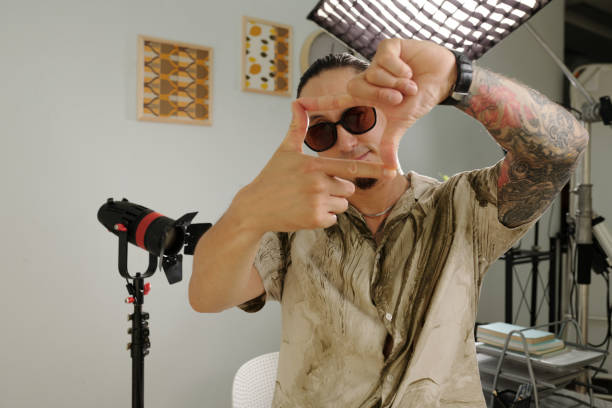 Portrait of professional cameraman making the best shot while standing in studio