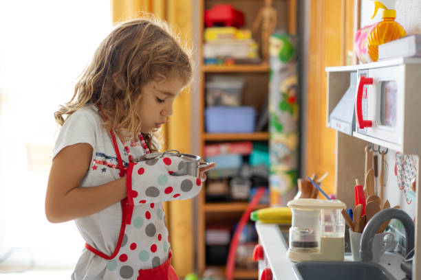 istock Little girl holding a pot while playing at toy kitchen 2178848068