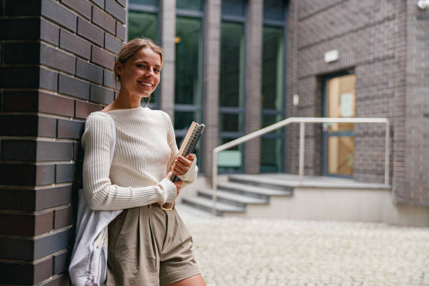 istock A young woman, stylish and relaxed, is seen in a modern urban environment, using her notebook 2178848579