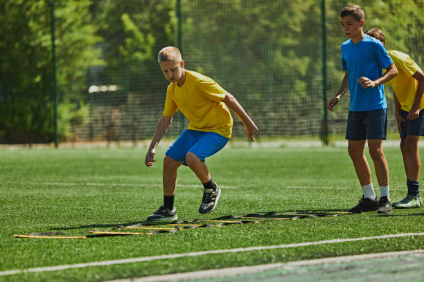 istock Focused Footwork Training. : Children in uniform training outdoors on soccer field, performing fast-paced agility drills 2178851539