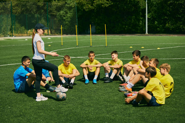 istock Team Strategy Session. Young soccer players studying with their coach, emphasizing educational and strategic aspects of sports training. 2178851576