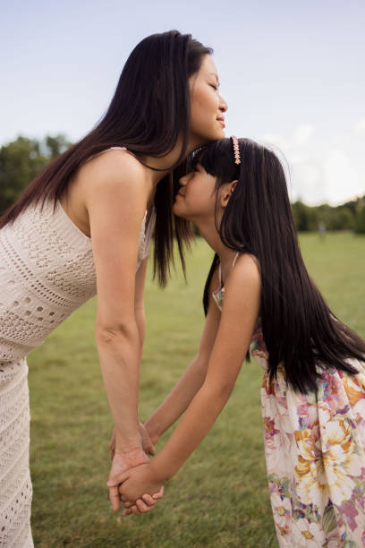 istock Affectionate Asian mother and daughter holding hands in nature. 2178851655