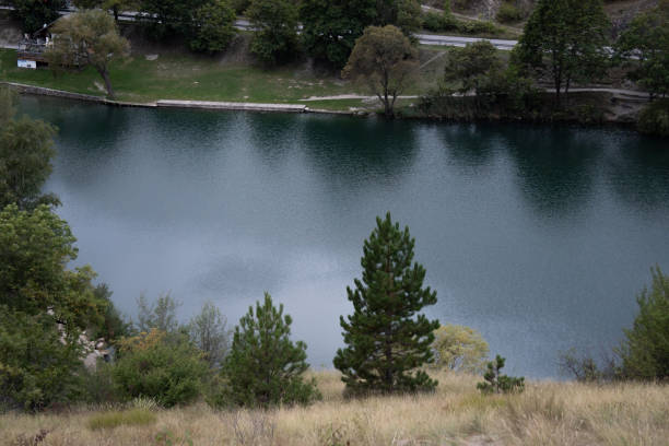 A tranquil lake with reflections of trees on the water, surrounded by greenery, offering a moment of calm and serenity in the heart of nature.