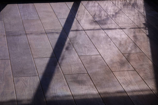 istock Sunlight Streaming Through a Window Casts Intricate Shadows on a Wooden Floor in a Serene Indoor Setting 2178855482