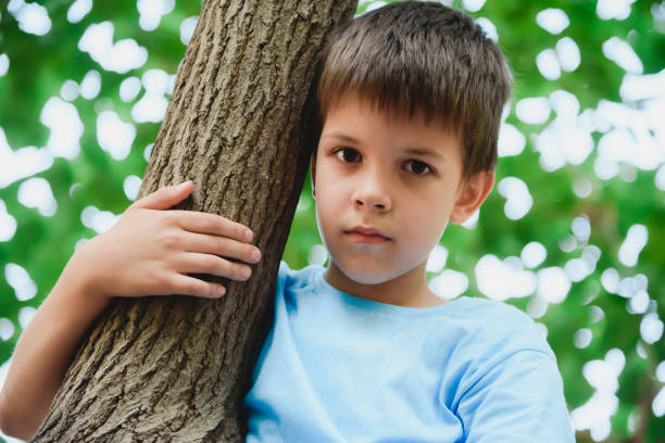 istock A boy climbs a tree in a park during the day 2178856608