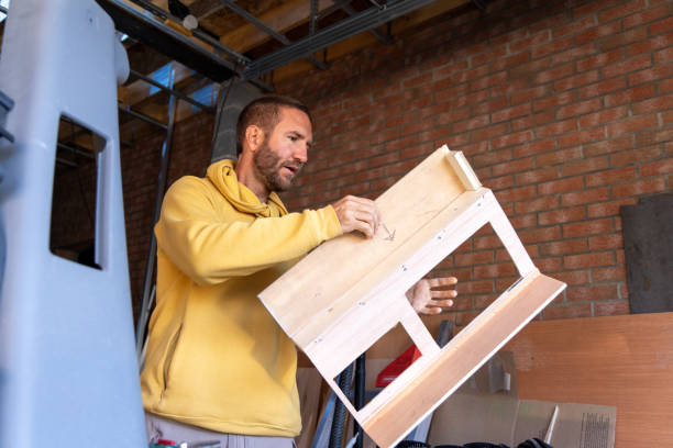 istock Man Inspecting a Wooden Frame in a Garage Workshop 2178859795