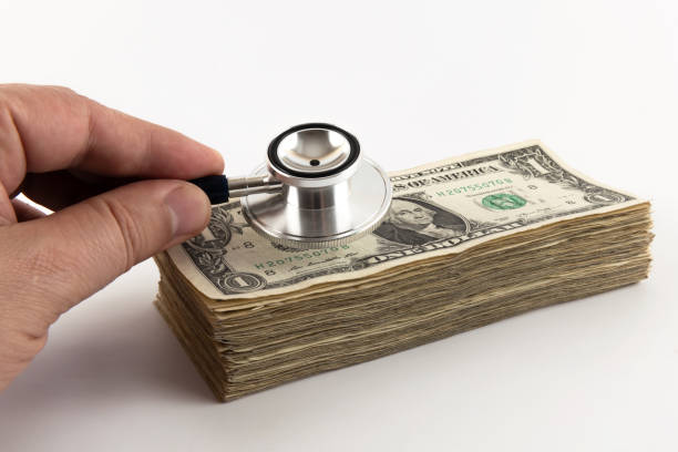 The head of a stethoscope and a stack of $1 bills