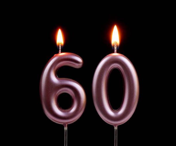istock Pink birthday candles isolated on black background, number 60 2178864449