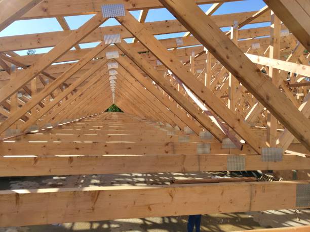istock Long row of angled wooden trusses forming a structural frame, emphasizing the orderly layout under bright daylight 2178866424