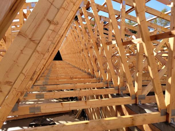 istock Perspective view down rows of wooden trusses, emphasizing the geometric layout and precision of the construction 2178866437