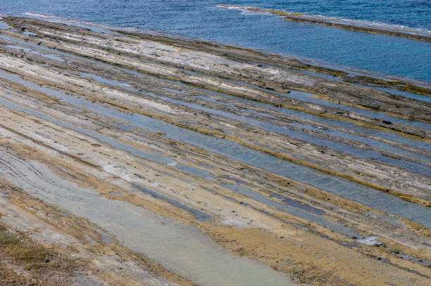 istock Stunning coastal landscape revealing layered rock formations at low tide under clear blue skies by the tranquil sea 2178868333