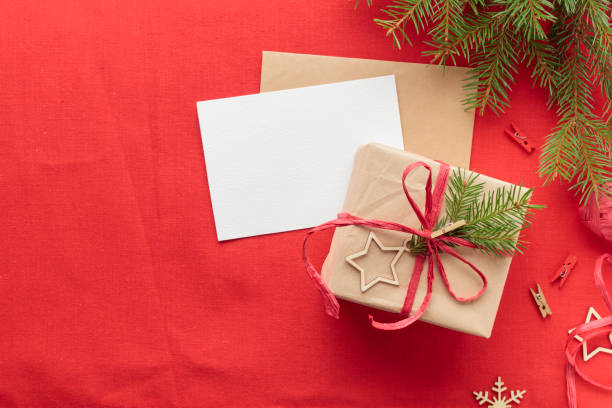 istock Christmas and zero waste, eco-friendly natural packaging gift in craft paper and a greeting card mockup on a wooden table, eco Christmas holiday concept, eco decor banner 2178869542