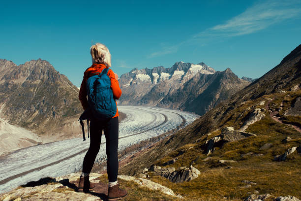 Senior woman hiking the Aletsch Glacier trail between Bettmeralp to Marjelen in the Valais district of Switzerland. This is the section nearer Marjelen.