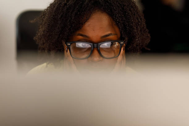 istock Young woman in eyeglasses reading data off the computer screen at her desk 2178873248