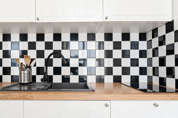 istock Kitchen sink with water tap in the kitchen with white black checked pattern textured tile on the wall. Home interior. 2178877062