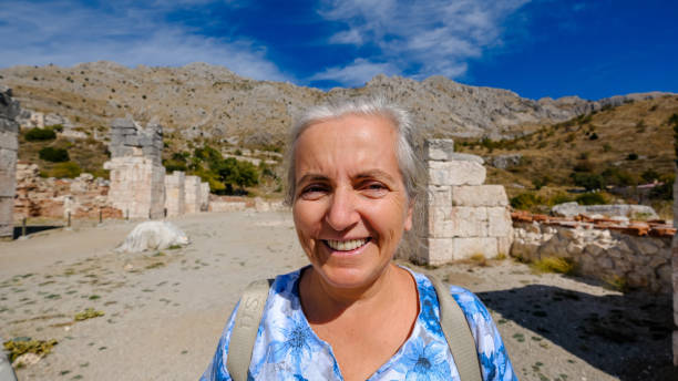 Portrait Of Senior Woman Wearing Hat Against Landscape