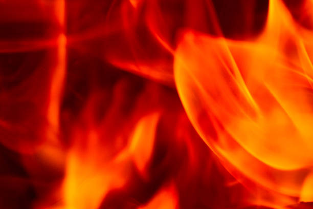 The flame glow orange in the dark. Fiery tongues create a bizarre pattern. Close-up.