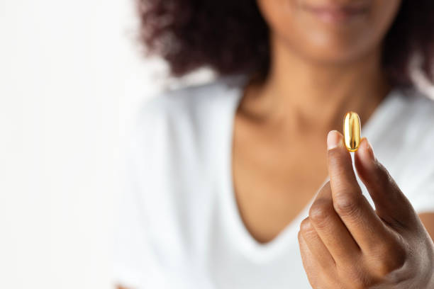 istock Woman Holding a Gold Capsule Pill 2178912438