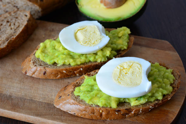 istock a wooden cutting board with avocado toast with mashed avocado on it and egg 2178913156