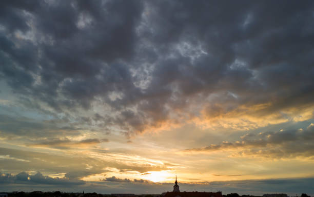 Dramatic sky at sunset with swirling clouds and warm hues, creating an enchanting atmosphere. Ideal for landscape lovers and nature enthusiasts.