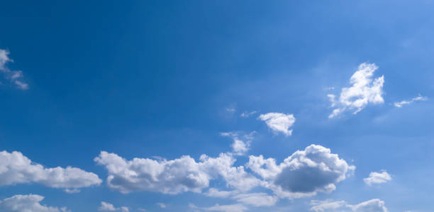 A serene blue sky with fluffy white clouds creating a tranquil backdrop, perfect for nature-themed projects or backgrounds.