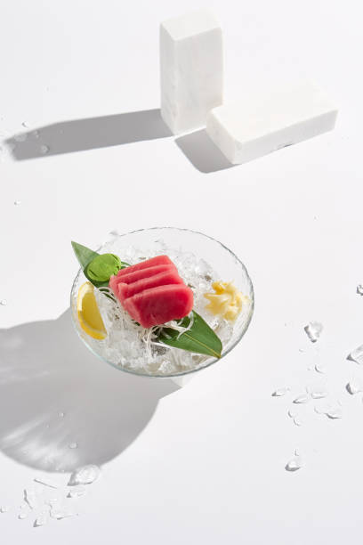 istock Minimalist Tuna Sashimi on Crushed Ice with Leaf Garnish and White Background 2178936086