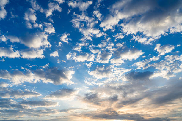 Cloudy blue sky with white and gray clouds at sunrise or dawn