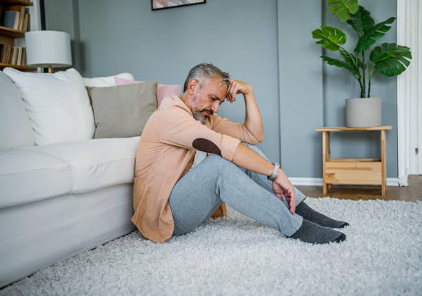 istock Depressed man sitting alone on the floor 2178943837