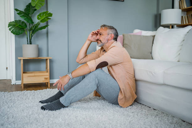 istock Depressed man sitting alone on the floor 2178944028