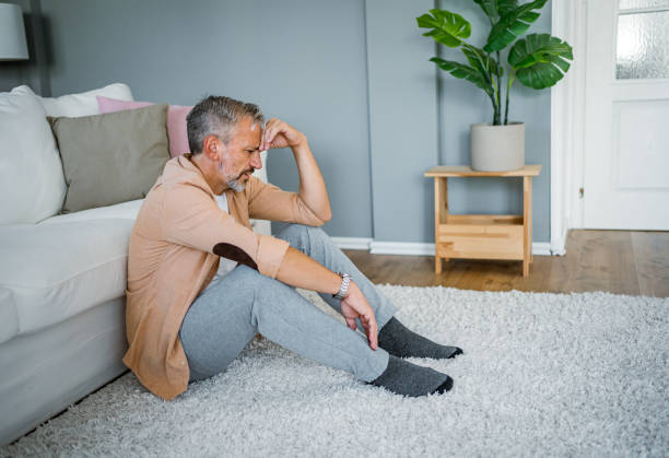 istock Depressed man sitting alone on the floor 2178944090