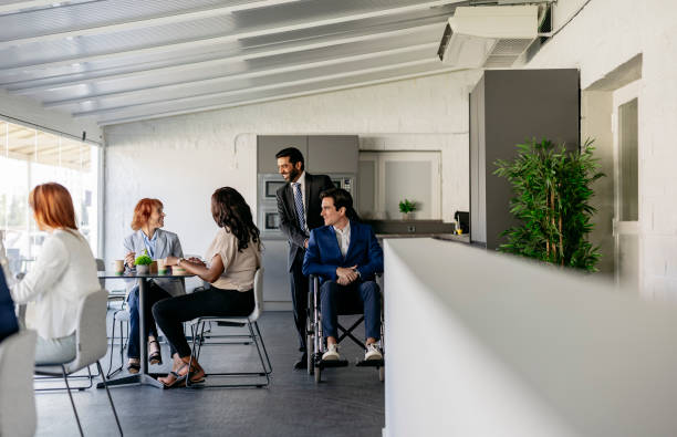 istock International business team discussing during office break in modern open space 2178951218