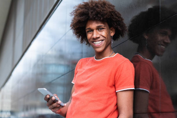 istock Delighted young ethnic guy using smartphone and smiling on street 2178952909