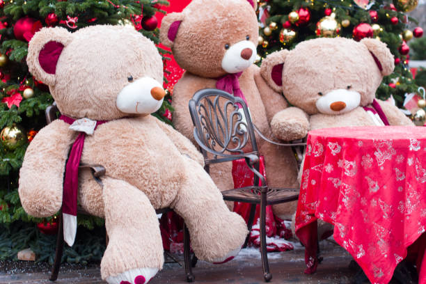 istock A teddy bear is sitting on a bench outside. New Year's holiday decor 2178954055